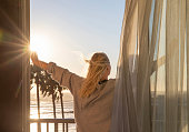 istock Woman relaxes on balcony at sunrise 1361409387