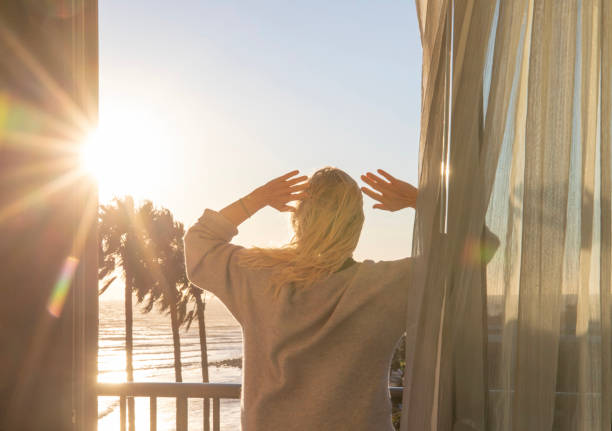 istock Woman relaxes on balcony at sunrise 1361409444
