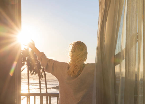 istock Woman relaxes on balcony at sunrise 1361409446