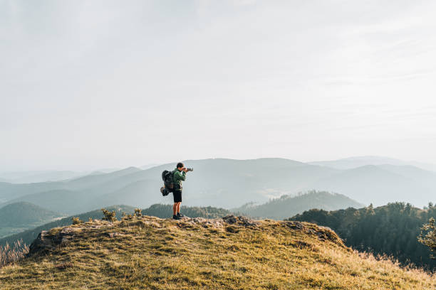 istock Hiker relaxes on grassy mountain ridge 1361410624