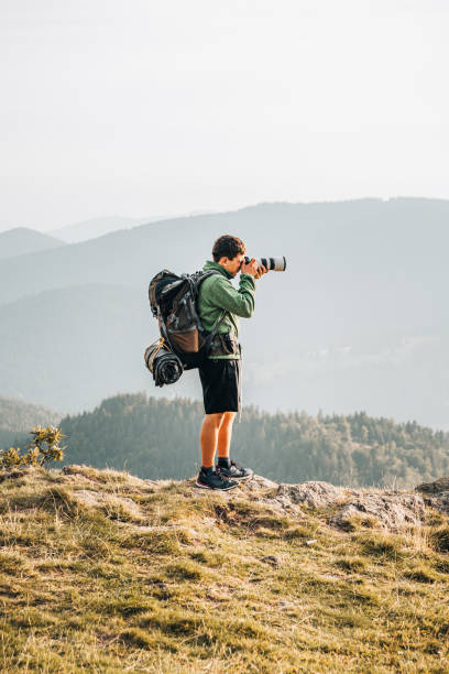 istock Hiker relaxes on grassy mountain ridge 1361410821