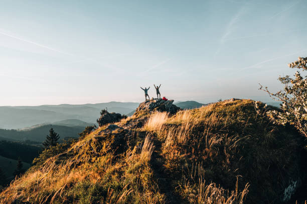 istock Hikers relax on grassy mountain ridge 1361411566
