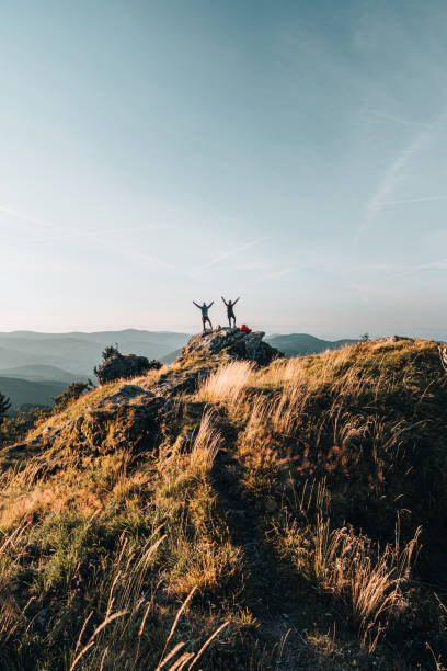 istock Hikers relax on grassy mountain ridge 1361411567