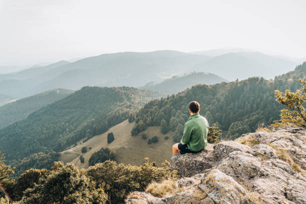 istock Hiker relaxes on grassy mountain ridge 1361411678