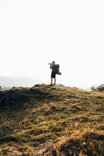 istock Hiker relaxes on grassy mountain ridge 1361411797