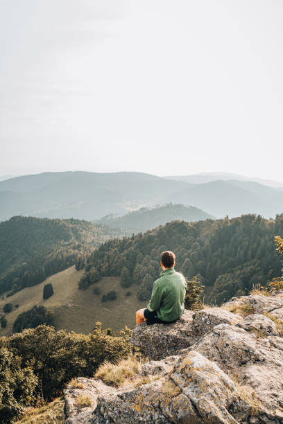 istock Hiker relaxes on grassy mountain ridge 1361412114