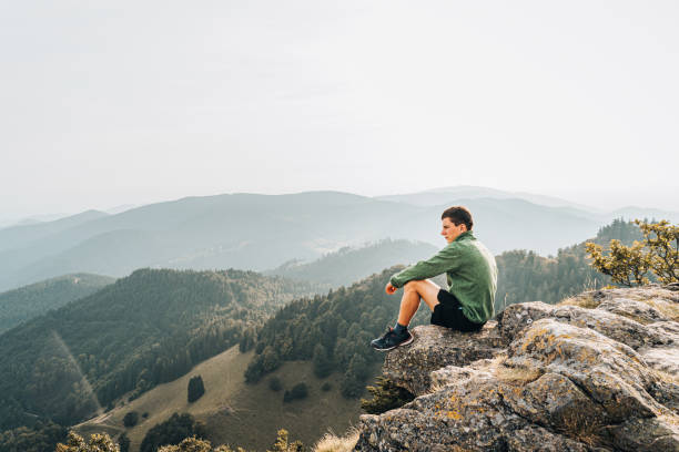 istock Hiker relaxes on grassy mountain ridge 1361413805