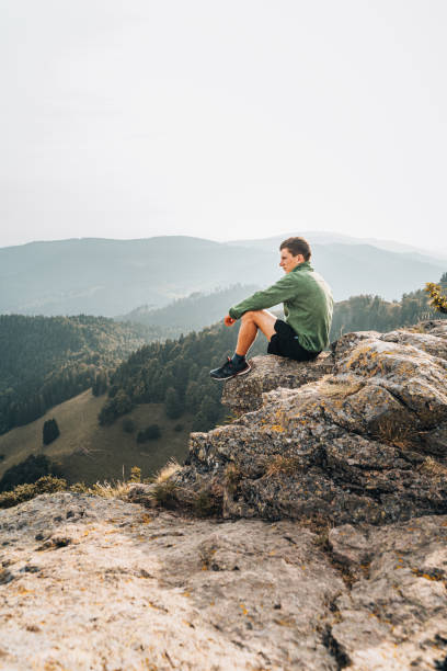 istock Hiker relaxes on grassy mountain ridge 1361414043