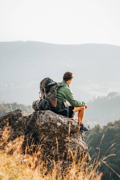 istock Hiker relaxes on grassy mountain ridge 1361414067