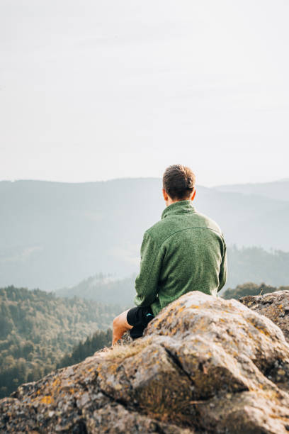 istock Hiker relaxes on grassy mountain ridge 1361414108
