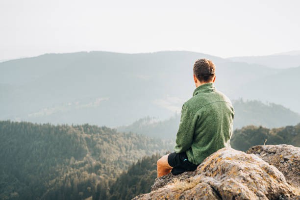 istock Hiker relaxes on grassy mountain ridge 1361414221