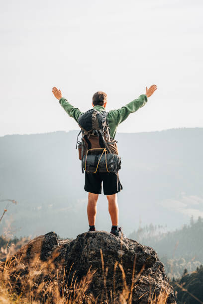 istock Hiker relaxes on grassy mountain ridge 1361415516