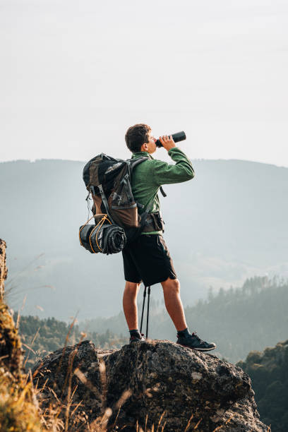 istock Hiker relaxes on grassy mountain ridge 1361415771