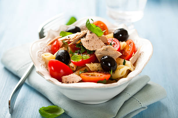 Pasta salad with tuna penne salad with tuna, olives and cherry tomatoes seafood salad stock pictures, royalty-free photos & images