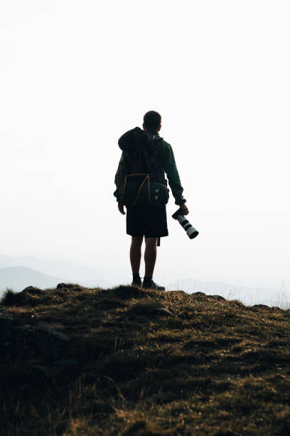 istock Photographer hikes along mountain ridge 1361417095