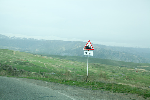 road in hills with a sharp descent against the background of fields