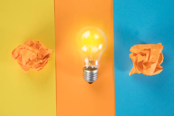 istock a light bulb and wads of paper on a multi-colored table 1361418042