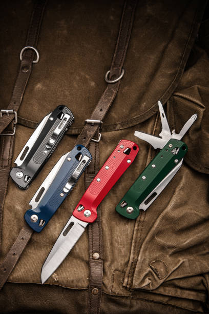 istock Folding multitool penknives on a khaki canvas backpack. A pocket-sized tool for hiking and daily life. 1361418239