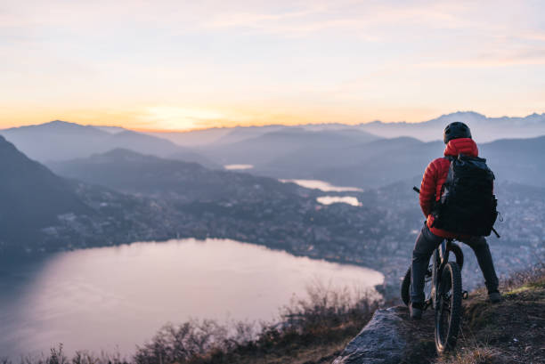 He looks out over Lake Lugano, toward the Swiss Alps