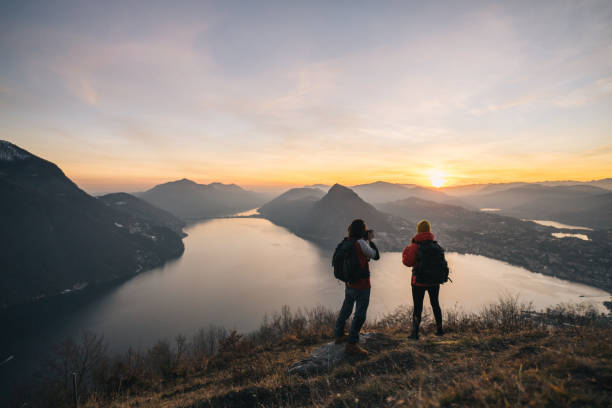 istock Hiking couple relax on grassy mountain ridge 1361420310