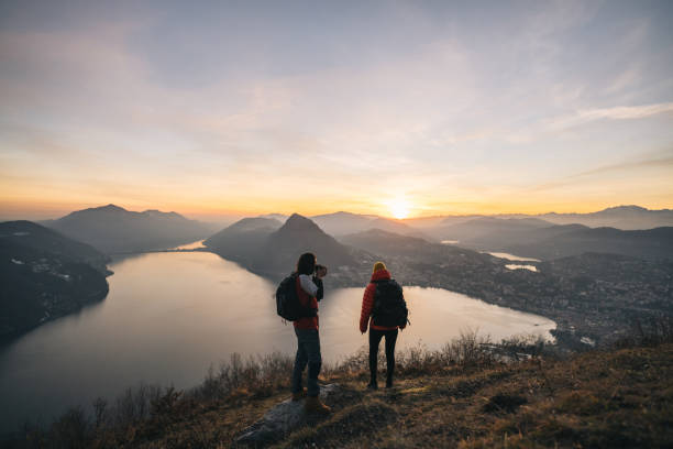 istock Hiking couple relax on grassy mountain ridge 1361420313
