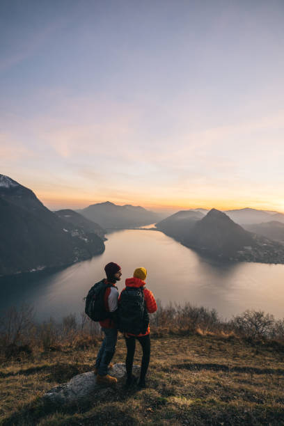 istock Hiking couple relax on grassy mountain ridge 1361420375