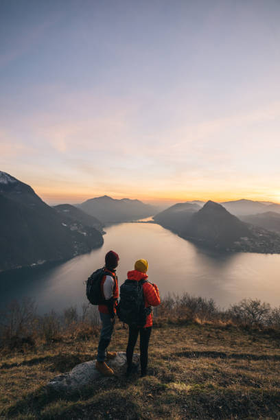 istock Hiking couple relax on grassy mountain ridge 1361420935