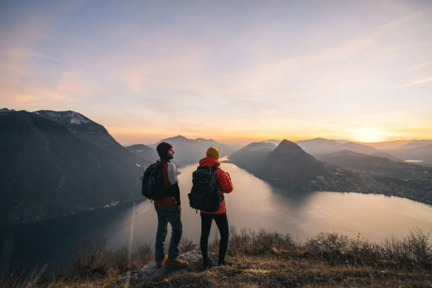 istock Hiking couple relax on grassy mountain ridge 1361420944