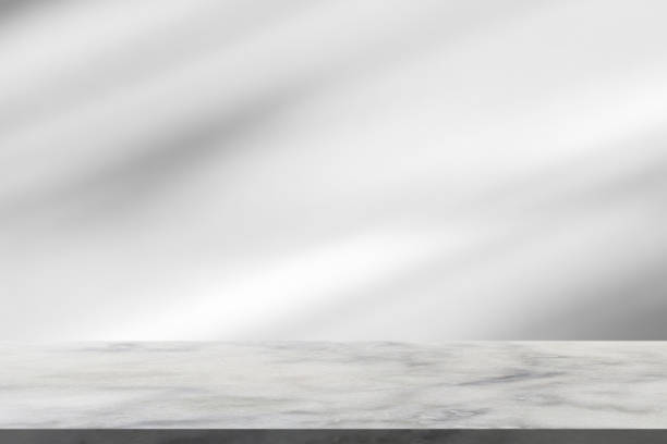 istock Marble table with window shadow drop on white wall background for mockup product display 1361423539