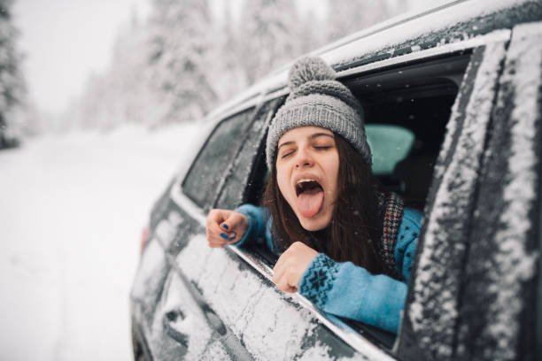 istock Young Woman Catching Snow Flakes Through Car Window During Snowfall 1361423706