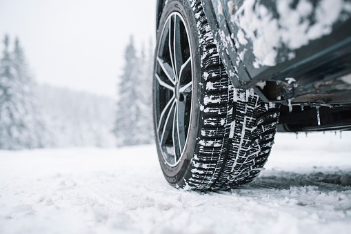 Primer plano del neumático del coche en una carretera nevada photo