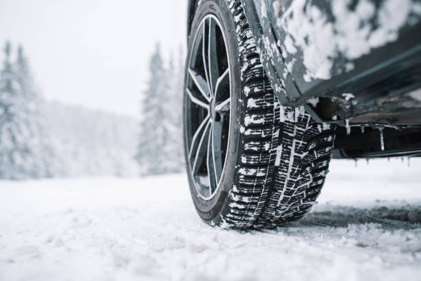 primo piano del pneumatico dell'auto sulla strada innevata - off road vehicle 4x4 snow driving foto e immagini stock