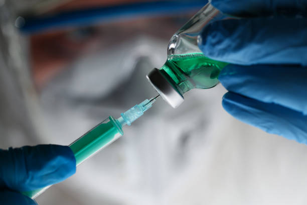 istock Scientist holding injection needle in hands in blue gloves 1361423803