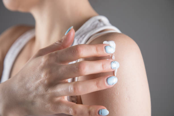 istock young woman smears her shoulder with cream 1361424272