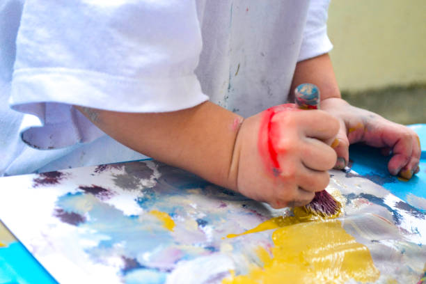 istock Girl's hands painting 1361437798