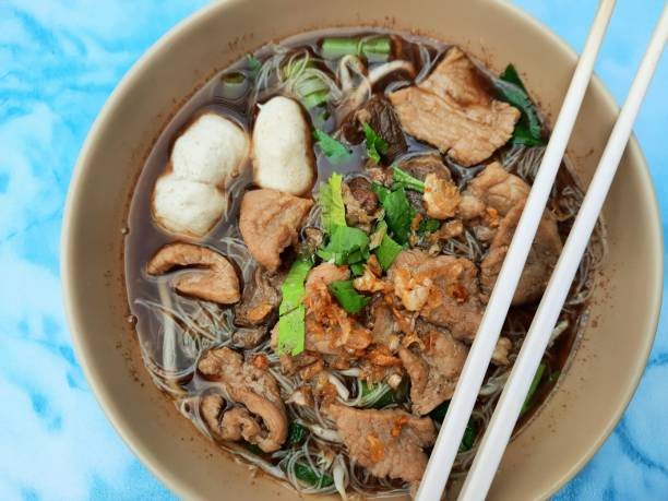 Eating Noodle soup with pork and meatball - Thai street food. stock photo
