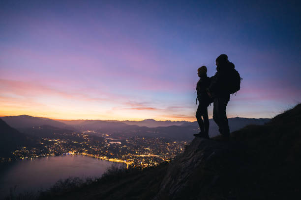 They chat and look out over Lake Lugano, toward the Swiss Alps