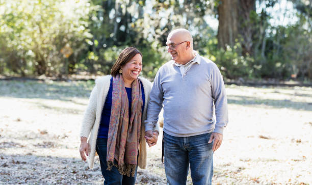istock Senior Hispanic couple walking in park holding hands 1361443441