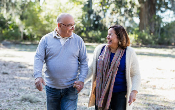 istock Senior Hispanic couple walking in park holding hands 1361443442