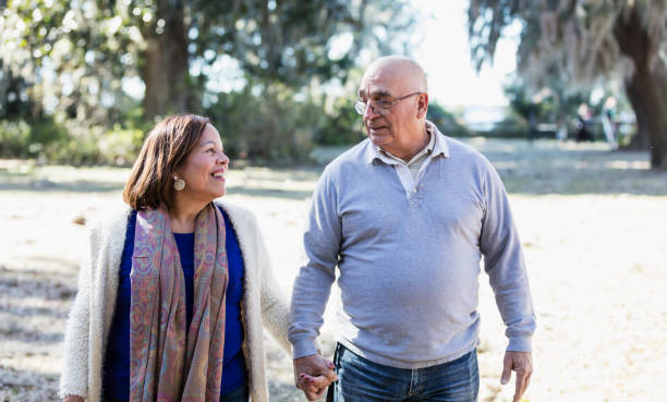 istock Senior Hispanic couple walking in park holding hands 1361443443