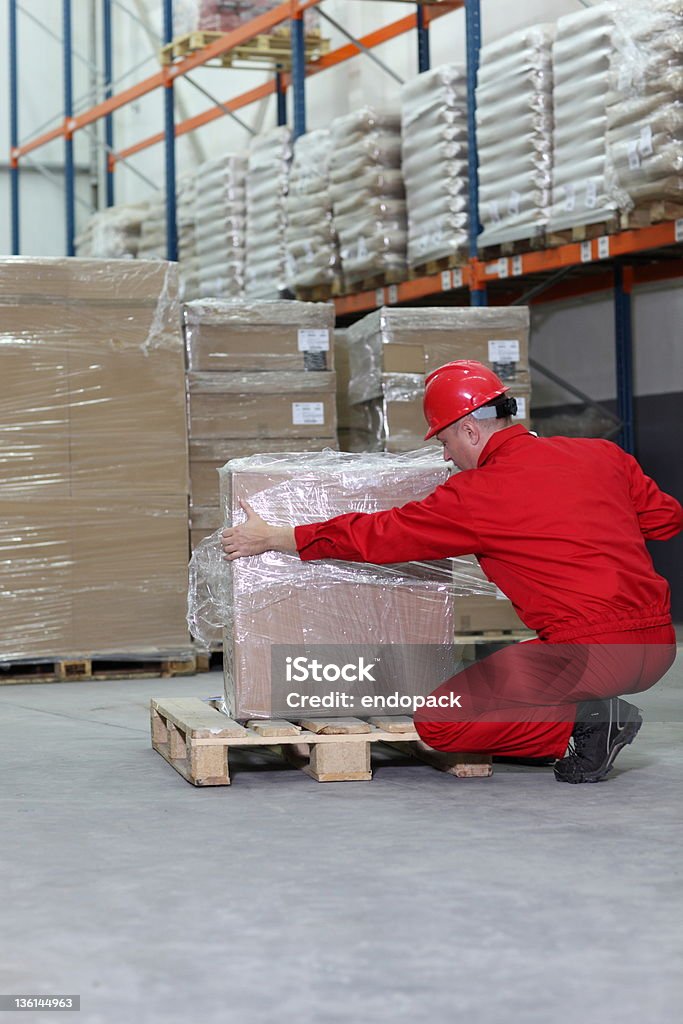 Trabalhador enrolar caixa na palete de madeira em armazém - Royalty-free Armazém Foto de stock