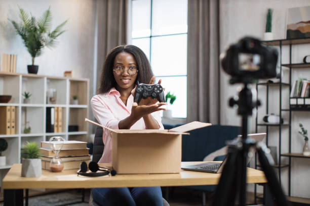 istock Positive woman opening parcel with wireless joystick 1361456969