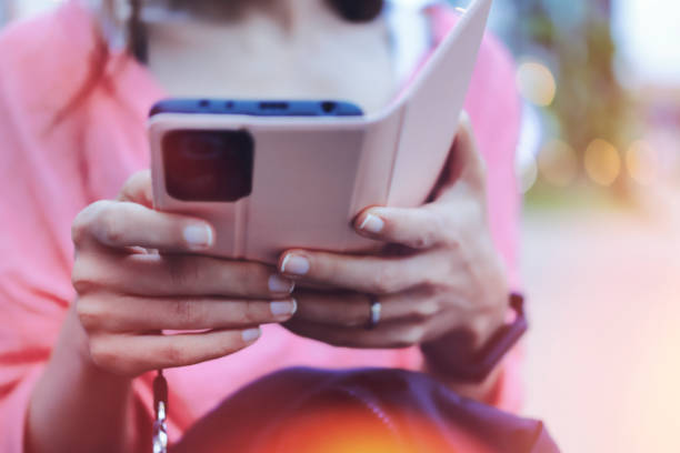 istock female hand using smartphone, natural blur background 1361456988