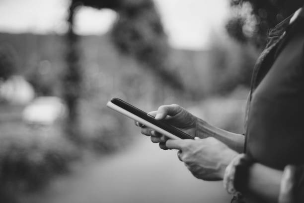 istock female hand using smartphone, natural blur background 1361457002