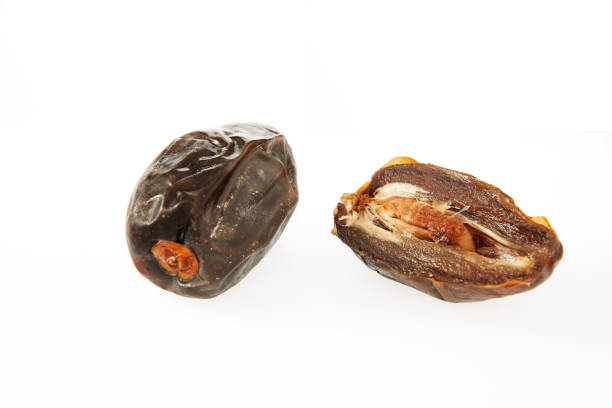 istock Fresh whole and half dates isolated on white background 1361457680