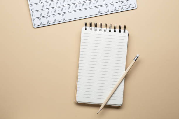 Workspace - Spiral notebook and keyboard stock photo