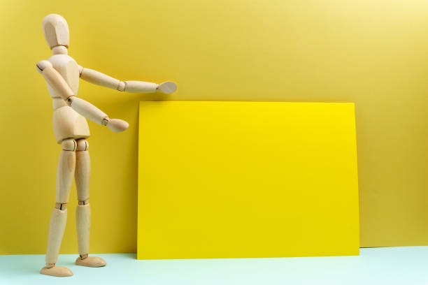 istock Wooden man presents empty space for your text copy. Yellow background 1361459971