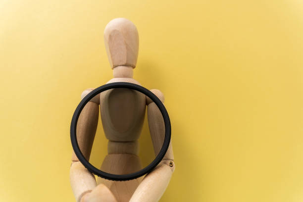 istock A polarizing filter in the hands of a wooden dummy with space for copying text. Accessory for the photographer 1361462860
