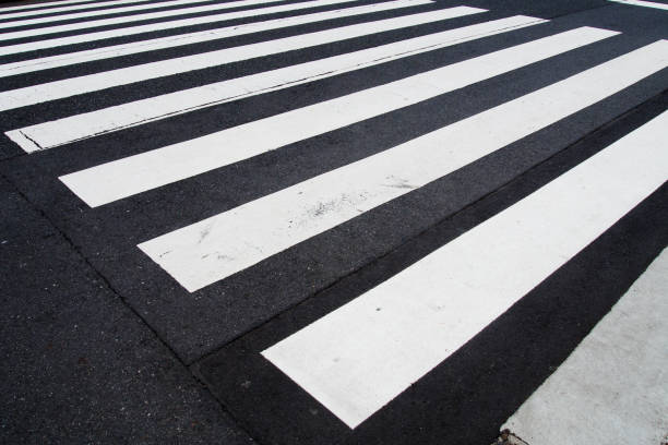 pedestrian crossing, white stripes on black asphalt, road markings zebra crossing, place to cross the road, traffic rules stock photo