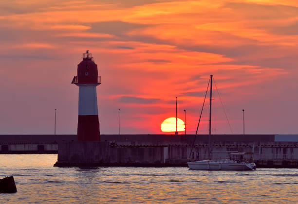istock Yacht at the sea lighthouse at sunset 1361463966